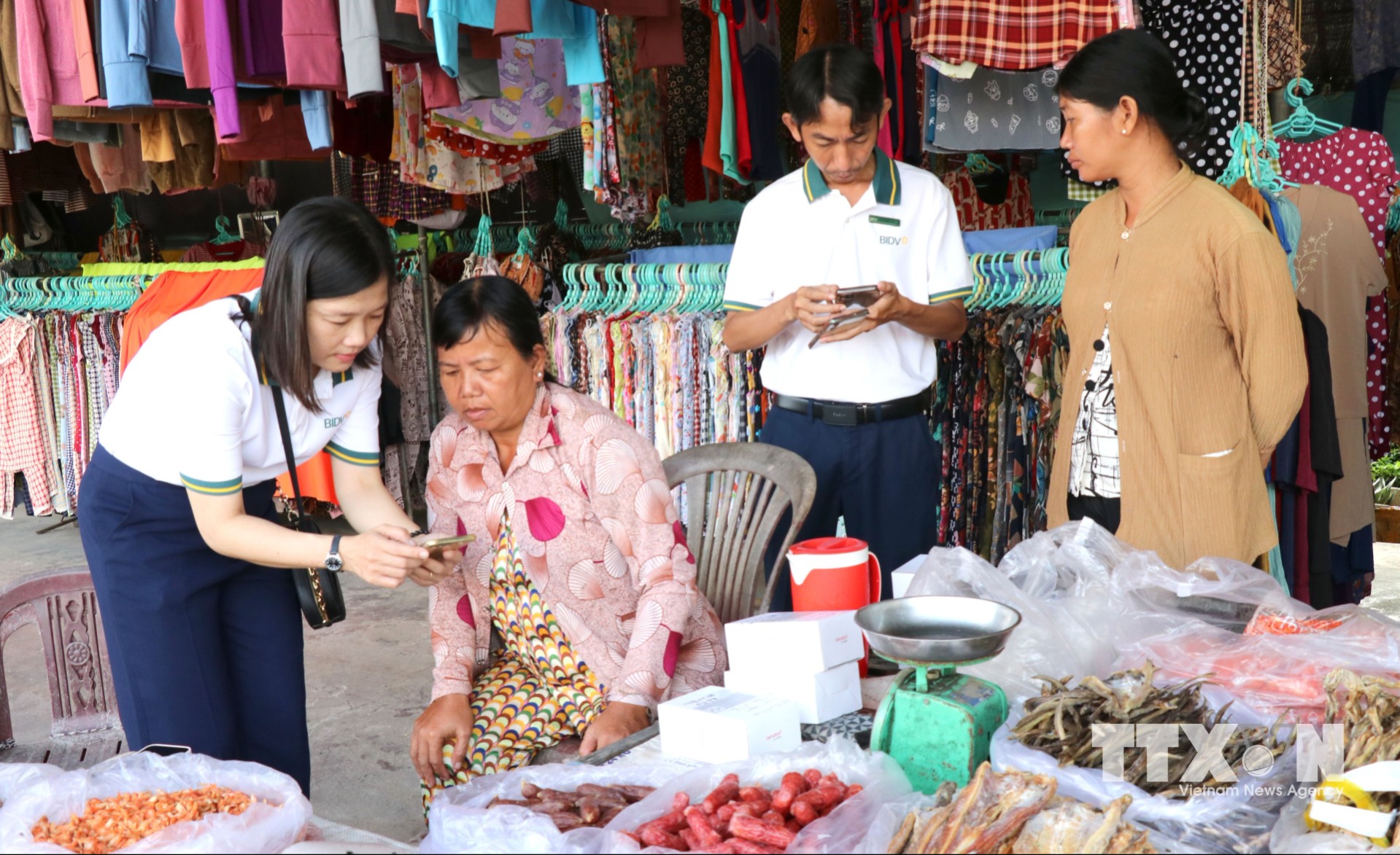 Hỗ trợ tiểu thương chợ Cầu Xây, xã Song Lộc, tỉnh Vĩnh Long, tải khoản ngân hàng và hướng dẫn sử dụng. (Ảnh: Thanh Hòa/TTXVN)